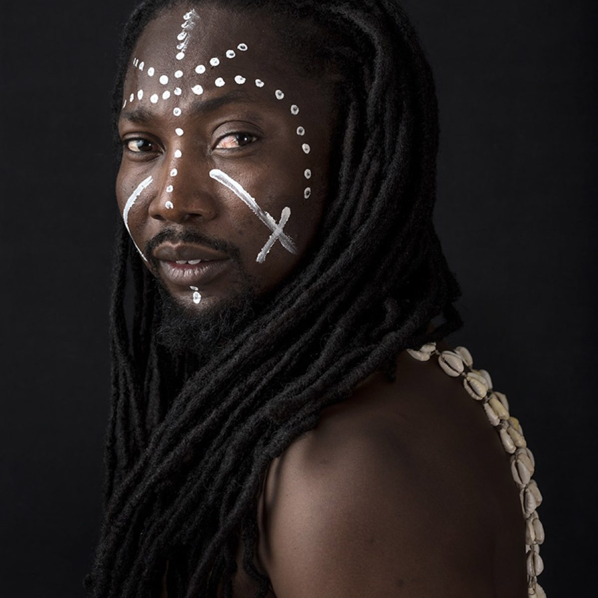 Een portret van Ayovi in met traditionele gezichtverf