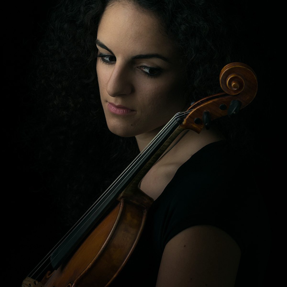 Een portret van Gulce met een cello bij heel zacht daglicht